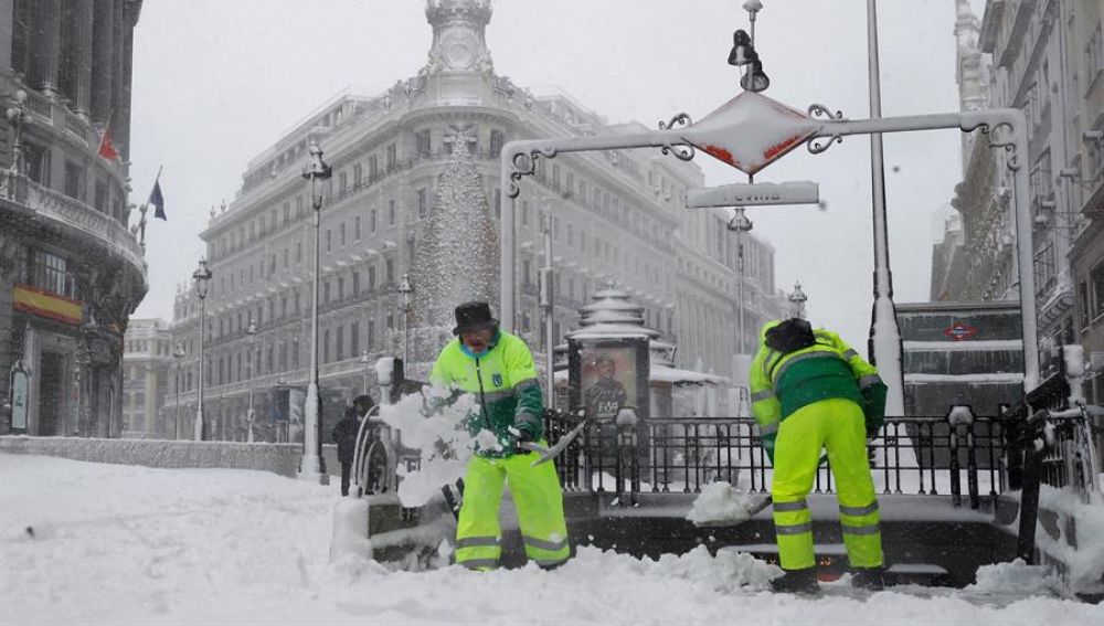 Operarios quitan la nieve en las cercanías a la Puerta del Sol de Madrid