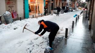 Un vecino retira nieve de la calzada en calle Le&oacute;n de Madrid. 