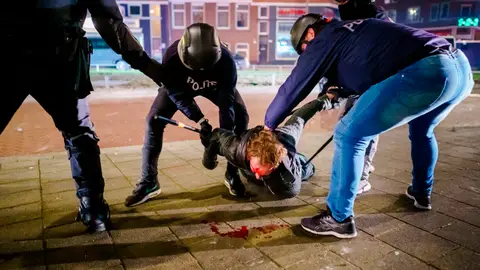 Un hombre es reducido por varios policías durante los distubios registrados anoche en Rotterdam, Países Bajos Un hombre es reducido por varios policías durante los distubios registrados anoche en Rotterdam, Países Bajos