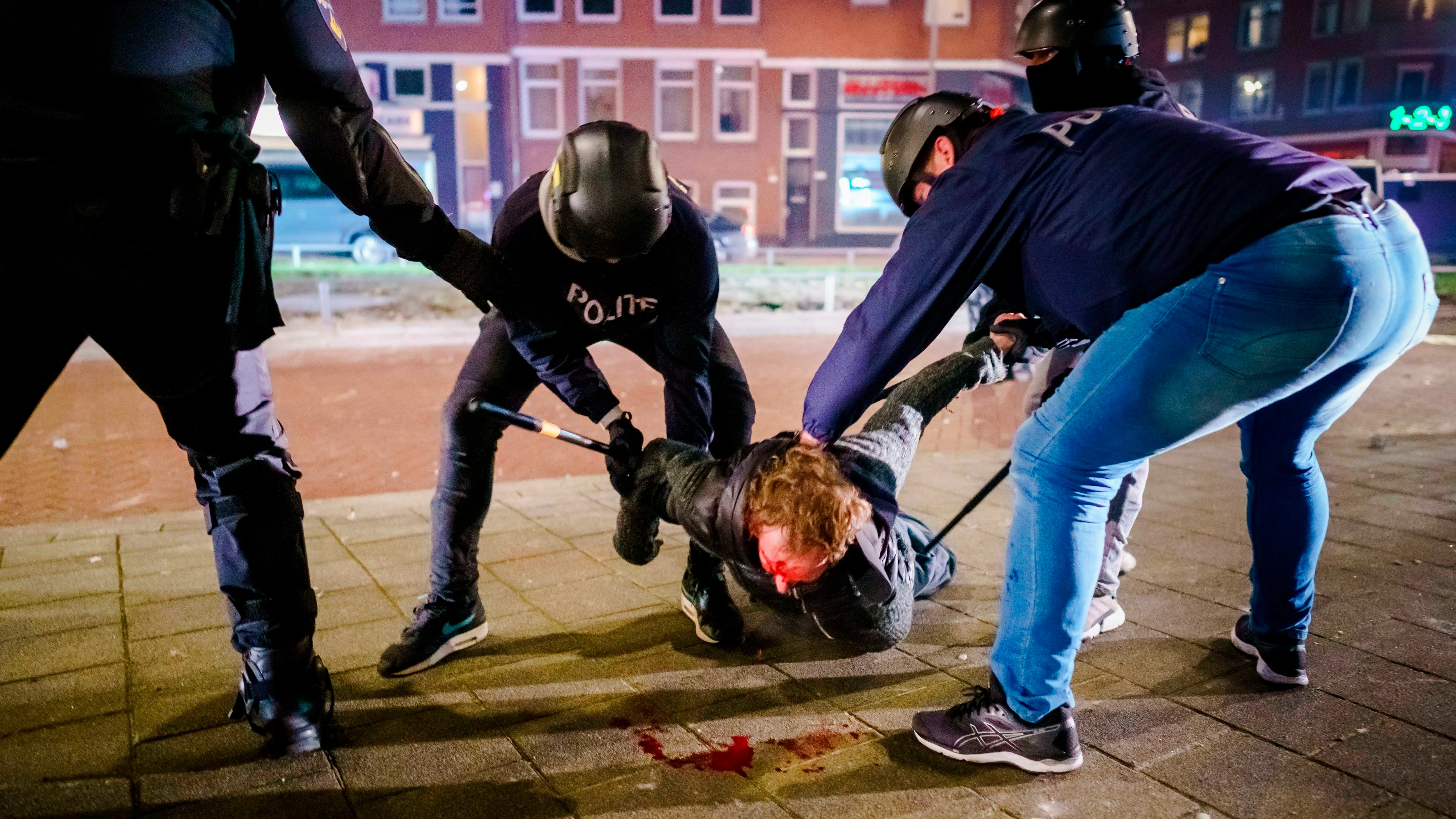 Un hombre es reducido por varios policías durante los distubios registrados anoche en Rotterdam, Países Bajos Un hombre es reducido por varios policías durante los distubios registrados anoche en Rotterdam, Países Bajos