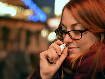 Mujer con un spray nasal Mujer con un spray nasal