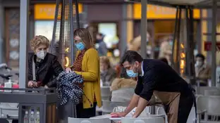 Un camarero limpia una terraza en Asturias Un camarero limpia una terraza en Asturias