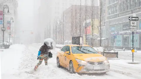 Una mujer corre hacia un taxi en Union Square Una mujer corre hacia un taxi en Union Square