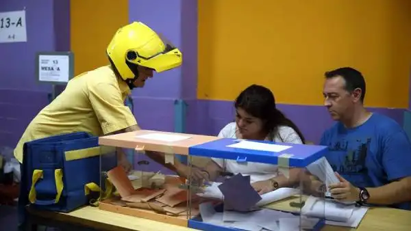 Imagen de archivo de un cartero entregando el voto por correo en una mesa electoral Imagen de archivo de un cartero entregando el voto por correo en una mesas electoral del Colegio Santa Marta de l'Hospitalet de Llobregat