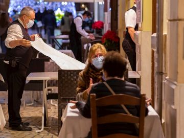 Varias personas con mascarilla en una terraza de Málaga