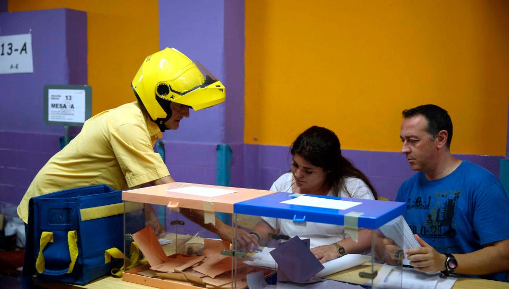 Elecciones Cataluña 2021: Un cartero entrega el voto por correo en una mesas electoral del Colegio Santa Marta de l'Hospitalet de Llobregat