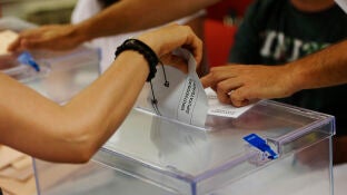 Una persona deposita su voto en una urna