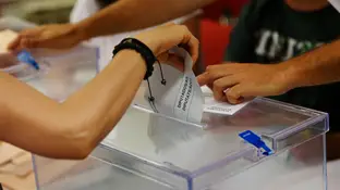 Una persona deposita su voto en una urna Una persona deposita su voto en una urna