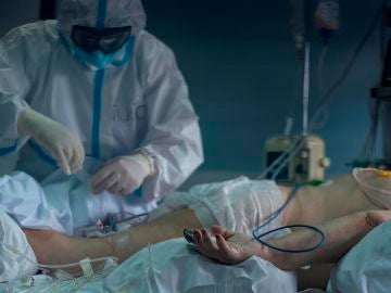 Un trabajador sanitario atiende a un paciente con coronavirus en la UCI del Hospital Cosaga de Ourense