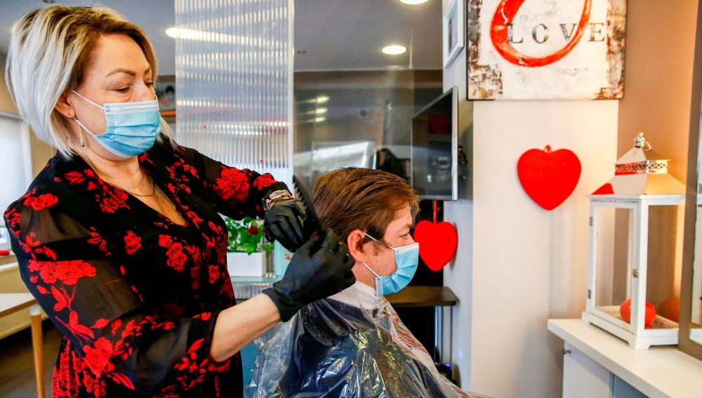 Una peluquera atiende a una clienta en Bruselas.