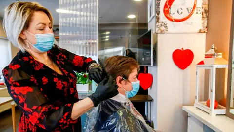 Una peluquera atiende a una clienta en Bruselas. Coronavirus