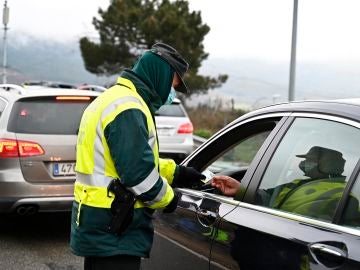 Un guardia civil pide la documentación a un conductor en un control de carretera a la altura de Guadarrama (Madrid)