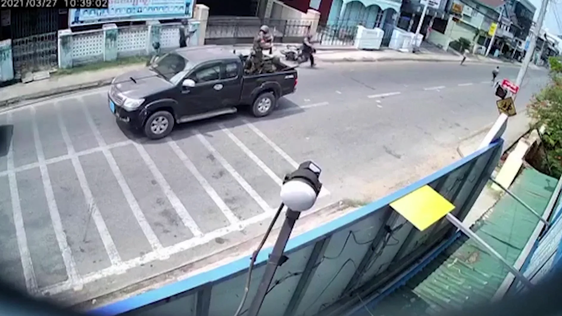 Tres hombres vestidos de militares disparando a la gente