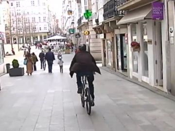 Un hombre circula en bicicleta por una calle en Ferrol