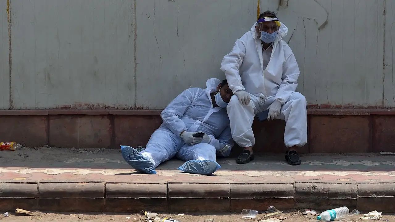 Dos paramédicos indios se toman un descanso a las puertas del depósito de cadáveres de un hospital en Nueva Delhi (India) este jueves Dos paramédicos indios se toman un descanso a las puertas del depósito de cadáveres de un hospital en Nueva Delhi (India) este jueves
