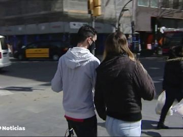 Dos jóvenes con mascarilla en la calle