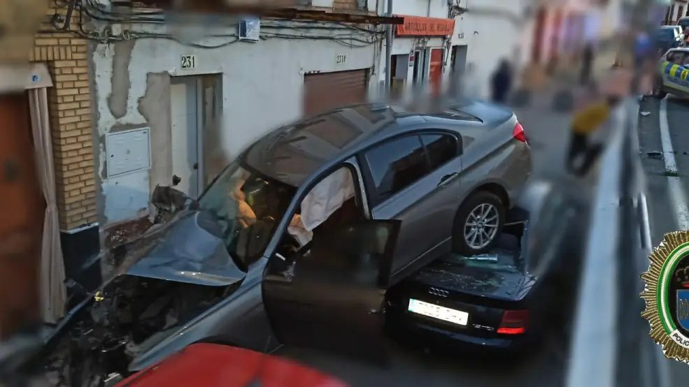 Espectacular accidente de un coche en El Viso (Andaluc&iacute;a) tras caer por un desnivel y quedar encima de otros turismos aparcados