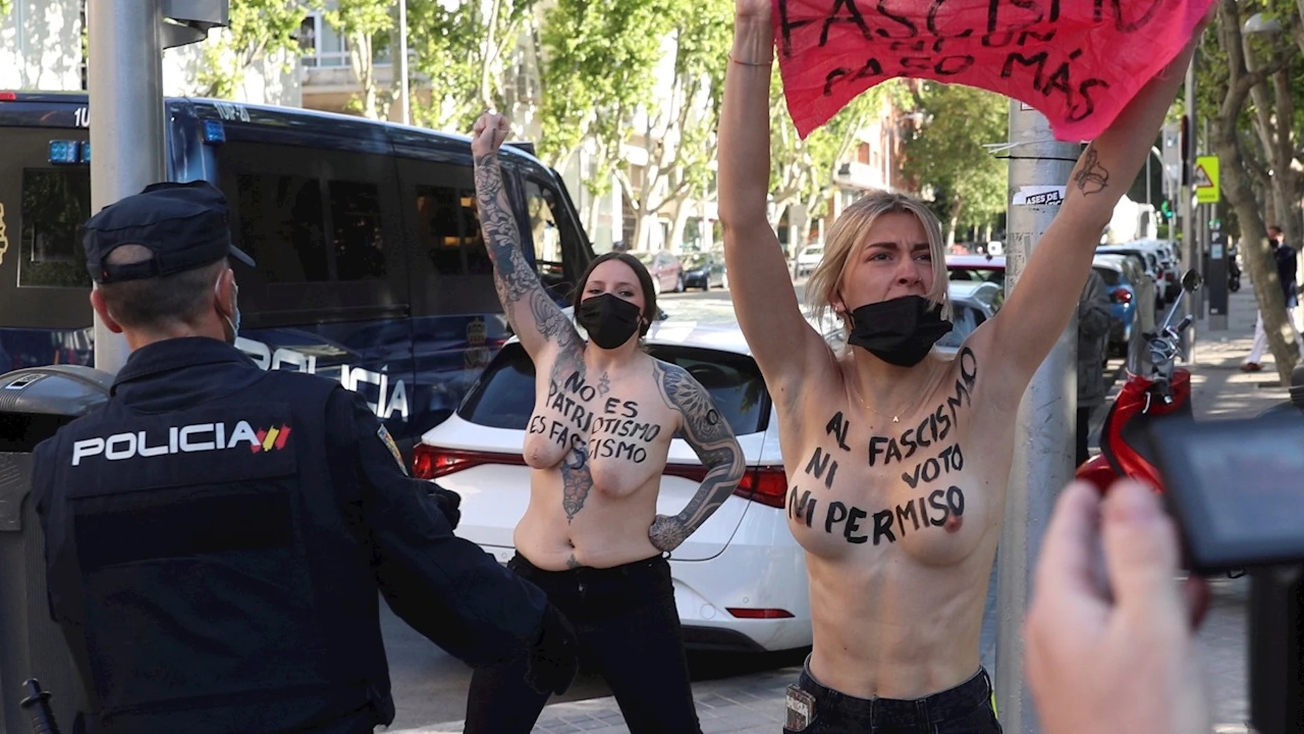 Unas activistas de FEMEN que protestaban delante del colegio San Agustín en Madrid, donde tiene previsto votar Rocío Monasterio, candidata de Vox a la presidencia de la Comunidad de Madrid, son interceptadas por agentes de policía este martes, día de las elecciones a la Comunidad de Madrid