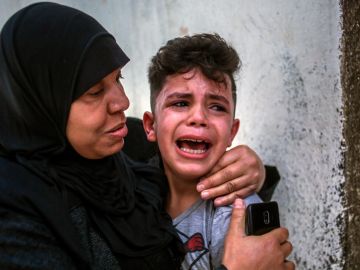 Una madre consuela a un niño asustado en Gaza