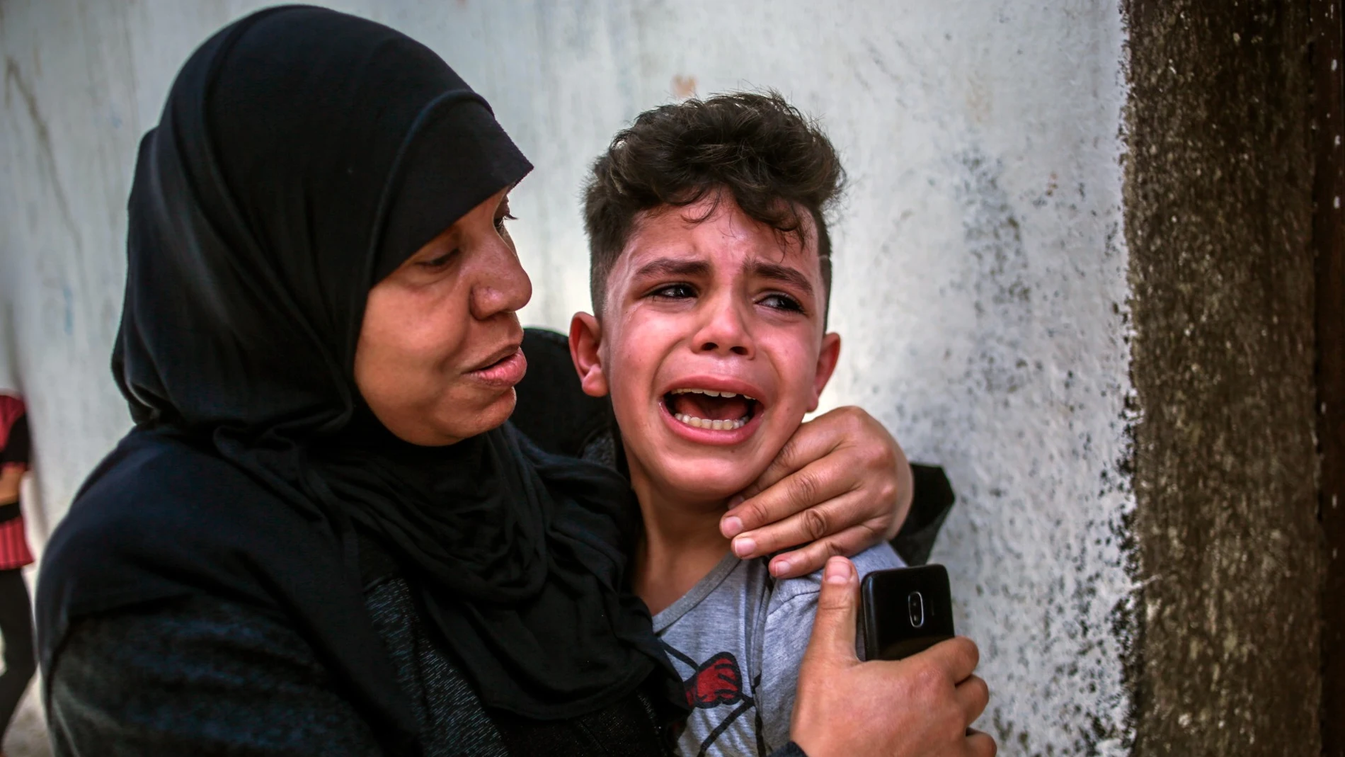 Una madre consuela a un niño asustado en Gaza
