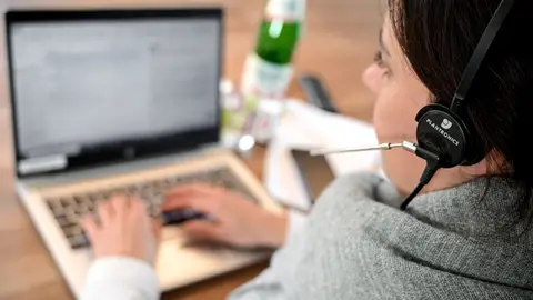 Una mujer trabajando con un ordenador Una mujer trabajando con un ordenador