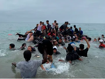 Un grupo de personas se hacen con una embarcación de las autoridades marroquíes en la playa de la localidad de Fnideq (Castillejos) Un grupo de personas se hacen con una embarcación de las autoridades marroquíes en la playa de la localidad de Fnideq (Castillejos)
