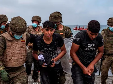 Agentes escoltan a migrantes en Ceuta Agentes escoltan a migrantes en Ceuta