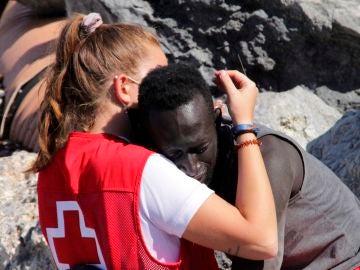 Voluntaria de Cruz Roja consuela a un migrante en Ceuta 
