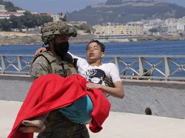Un soldado traslada a un inmigrante en la playa fronteriza de El Tarajal de Ceuta Un soldado traslada a un inmigrante en la playa fronteriza de El Tarajal de Ceuta