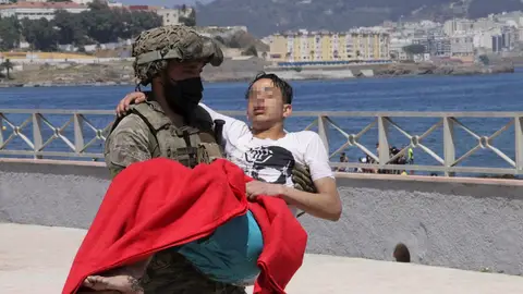 Un soldado traslada a un inmigrante en la playa fronteriza de El Tarajal de Ceuta Un soldado traslada a un inmigrante en la playa fronteriza de El Tarajal de Ceuta