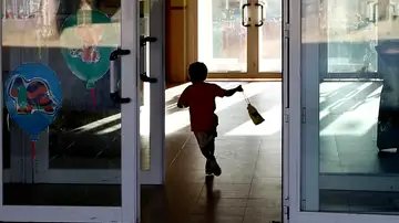 Un niño entrando al colegio corriendo Un niño entrando al colegio corriendo