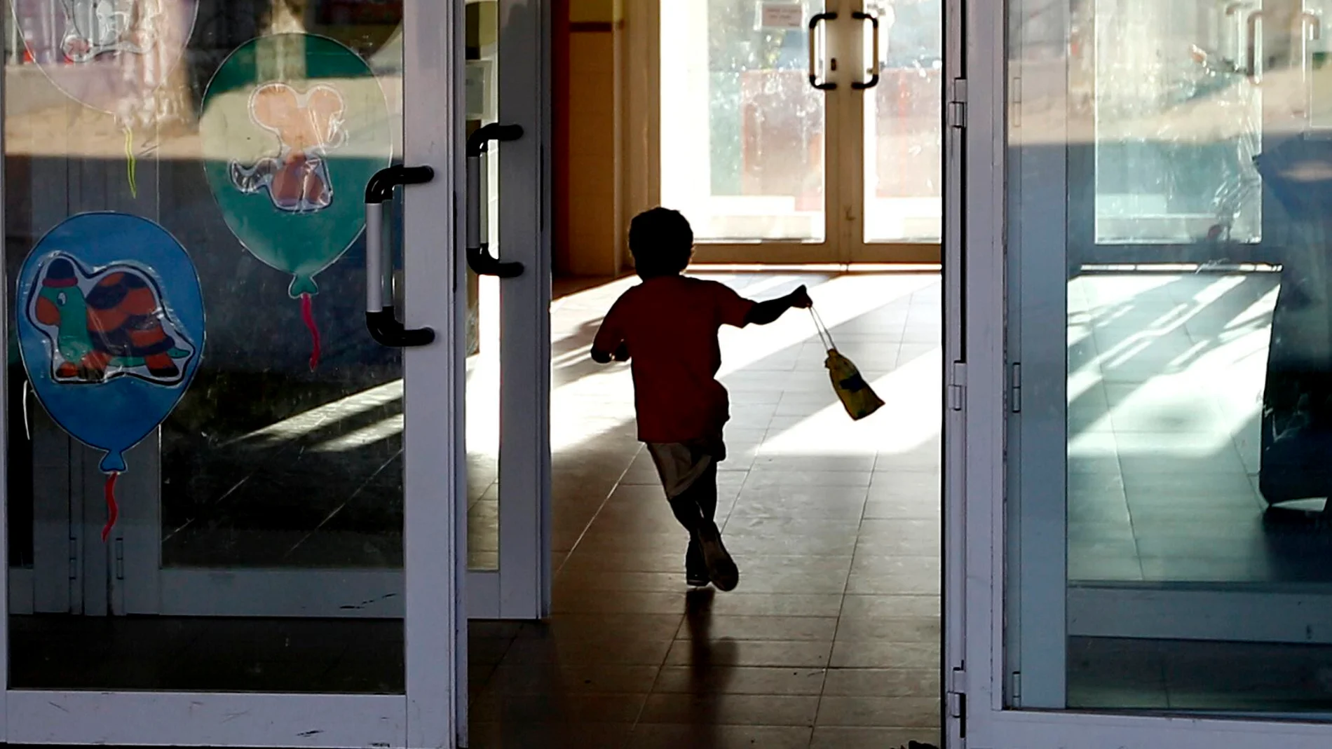 Un niño entrando al colegio corriendo