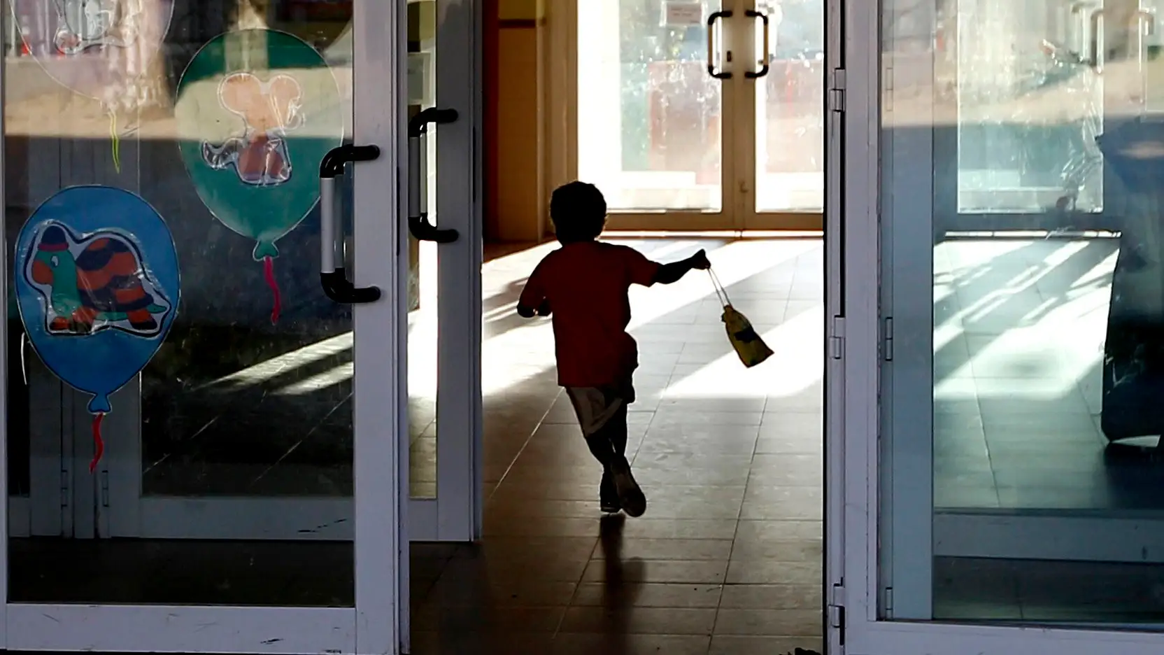 Un niño entrando al colegio corriendo Un niño entrando al colegio corriendo