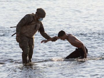  Un soldado del ejército ayuda a un inmigrante a su llegada a la playa de El Tarajal en Ceuta este miércoles