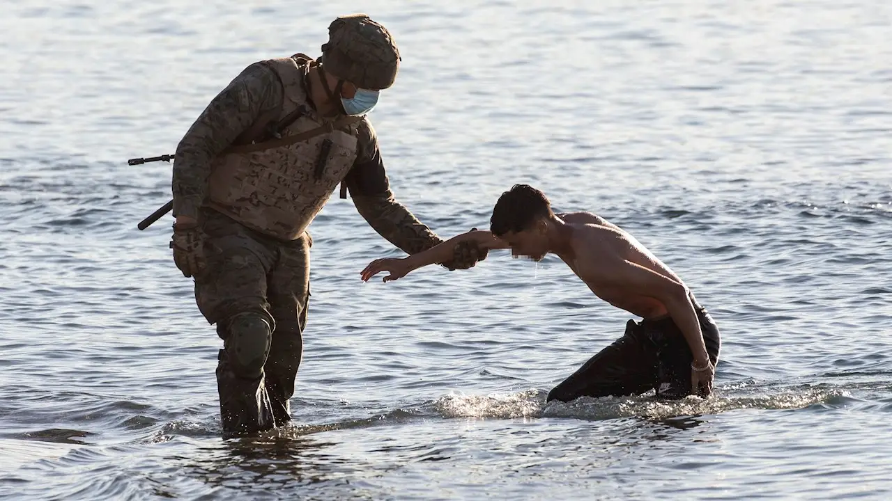 Un soldado del ejército ayuda a un inmigrante a su llegada a la playa de El Tarajal en Ceuta este miércoles Un soldado del ejército ayuda a un inmigrante a su llegada a la playa de El Tarajal en Ceuta este miércoles