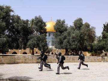 Agentes de la policía de Israel corren ante la explanada de la mezquita de Al-Aqsa.