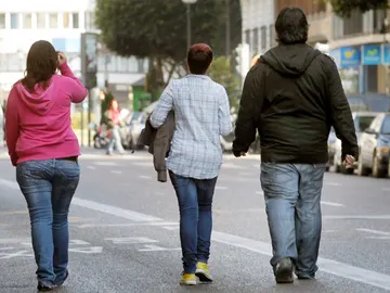 Tres jóvenes pasean por una calle de Valencia Tres jóvenes pasean por una calle de Valencia