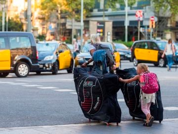 Unos turistas llevan sus maletas por las calles de Barcelona