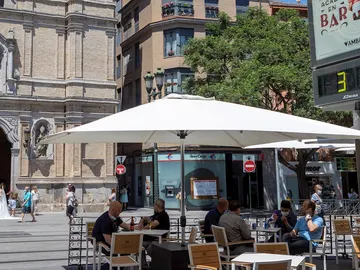 Unos ciudadanos aprovechan el buen tiempo en una terraza en Zaragoza Unos ciudadanos aprovechan el buen tiempo en una terraza en Zaragoza