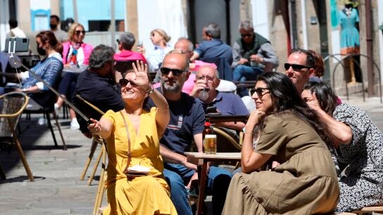 Unos turistas disfrutan este s&aacute;bado en una terraza en Santiago de Compostela