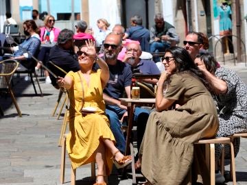 Unos turistas disfrutan este sábado en una terraza en Santiago de Compostela