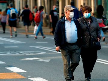 Una pareja pasea con mascarillas en Cataluña