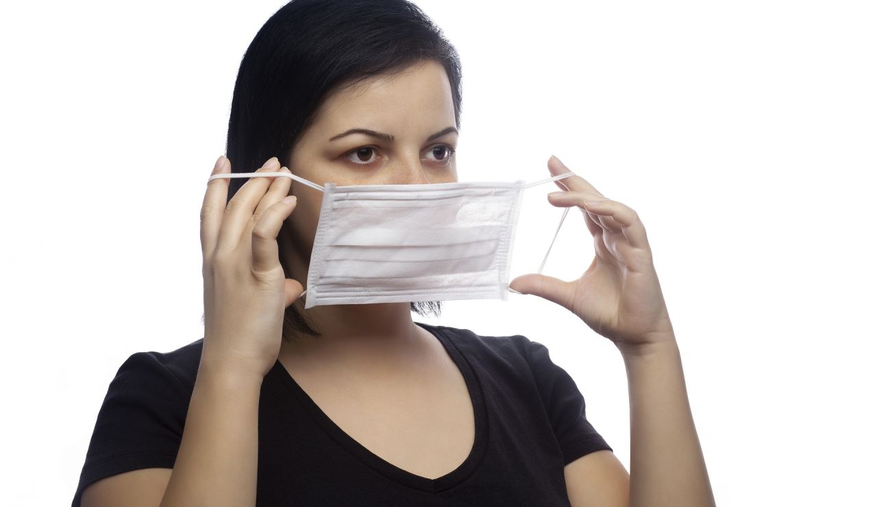 Mujer quitándose la mascarilla Mujer quitándose la mascarilla