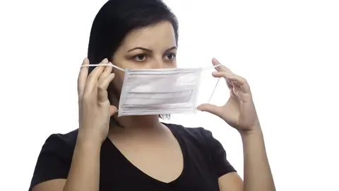 Mujer quitándose la mascarilla Mujer quitándose la mascarilla