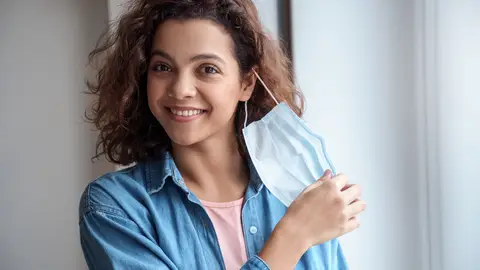 Mujer quitándose mascarilla Mujer quitándose mascarilla