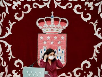 La presidenta madrileña, Isabel Díaz Ayuso, se coloca la mascarilla mientras preside la ceremonia de toma de posesión de los nuevos consejeros de la Comunidad de Madrid, este lunes, en la Real Casa de Correos. 