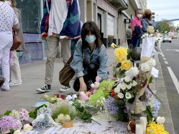 Una mujer deposita el pasado martes flores en el lugar donde asesinaron a Samuel Luiz, el joven de 24 años que perdió la vida en la madrugada del sábado tras recibir una paliza