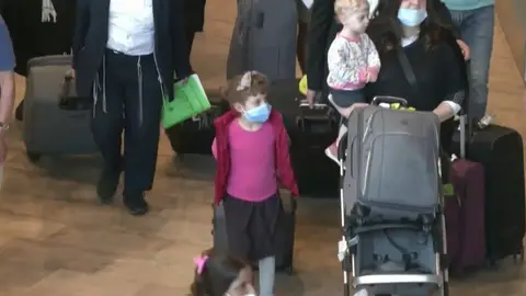 Una niña camina portando una mascarilla Una niña camina portando una mascarilla