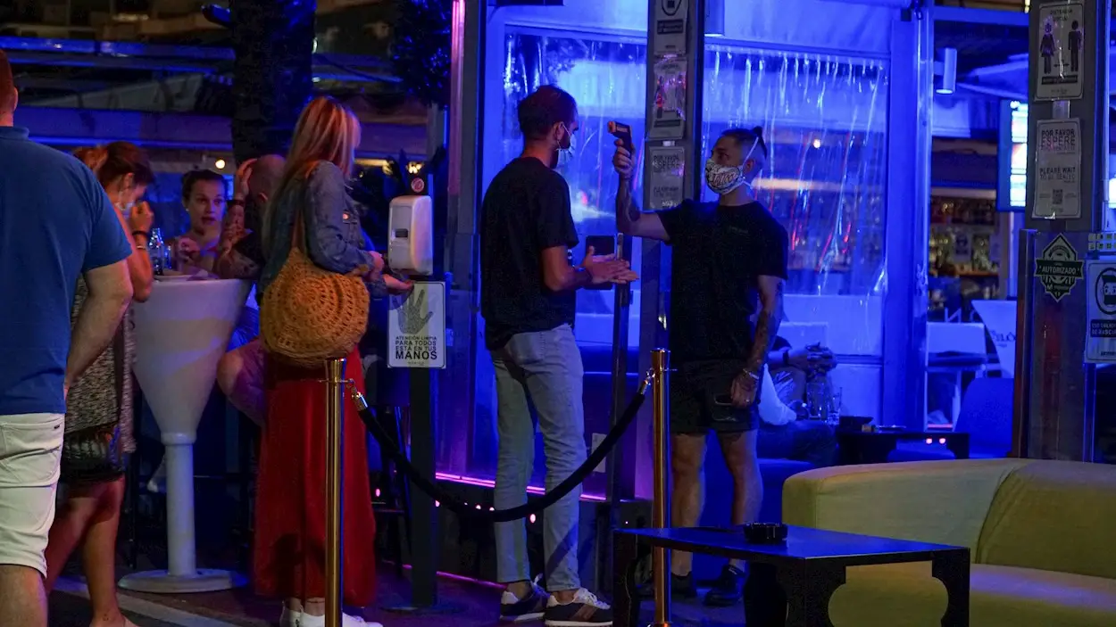 Un empleado toma la temperatura a un joven que hace cola para entrar en un pub en el puerto deportivo de Marbella. Un empleado toma la temperatura a un joven que hace cola para entrar en un pub en el puerto deportivo de Marbella.