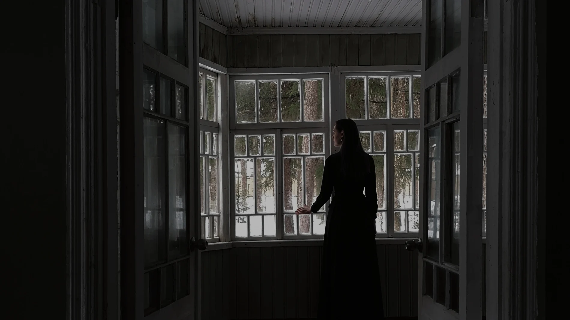 Una mujer mira por la ventana Una mujer mira por la ventana